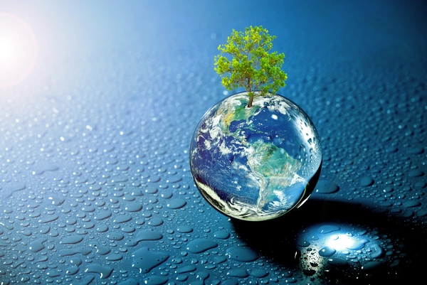 Miniatursymbol der Erde mit einem Baum darauf, daneben eine blaue Fläche mit Wassertropfen