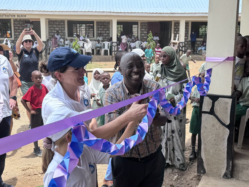 2 Erwachsende und ein Kind zerschneiden das Eröffnungsband.
