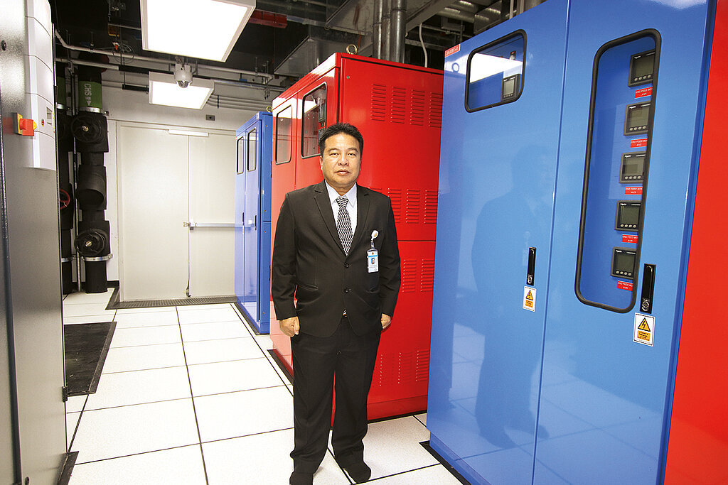 Mann im Anzug vor dem Rechenzentrum und einer blauen Sicherheitstür