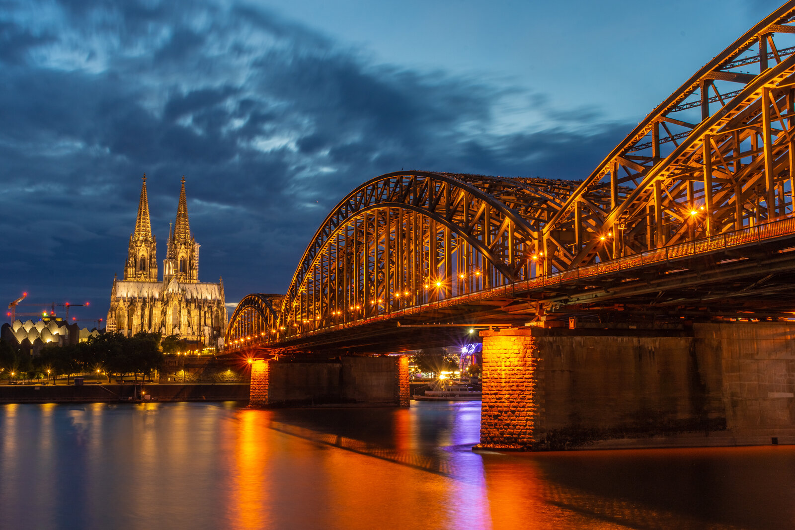 Skyline von Köln bei Nacht mit Kölner Dom und Bahn-Brücke