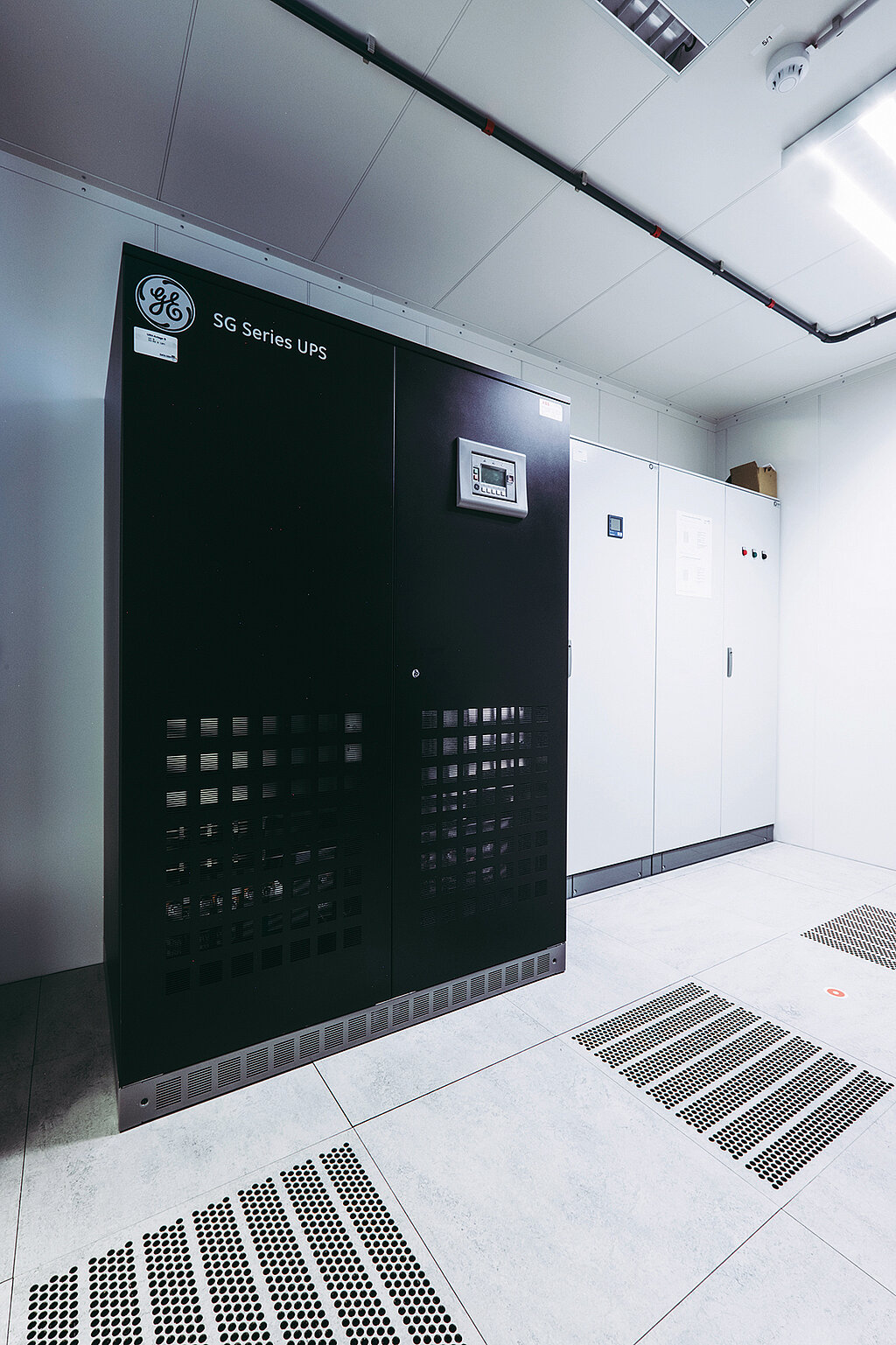 Serverschrank schwarz neben einem weißen Schrank