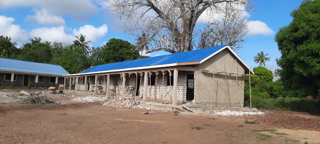 Schulgebäude mit gedecktem Dach und verputzter Außenwand