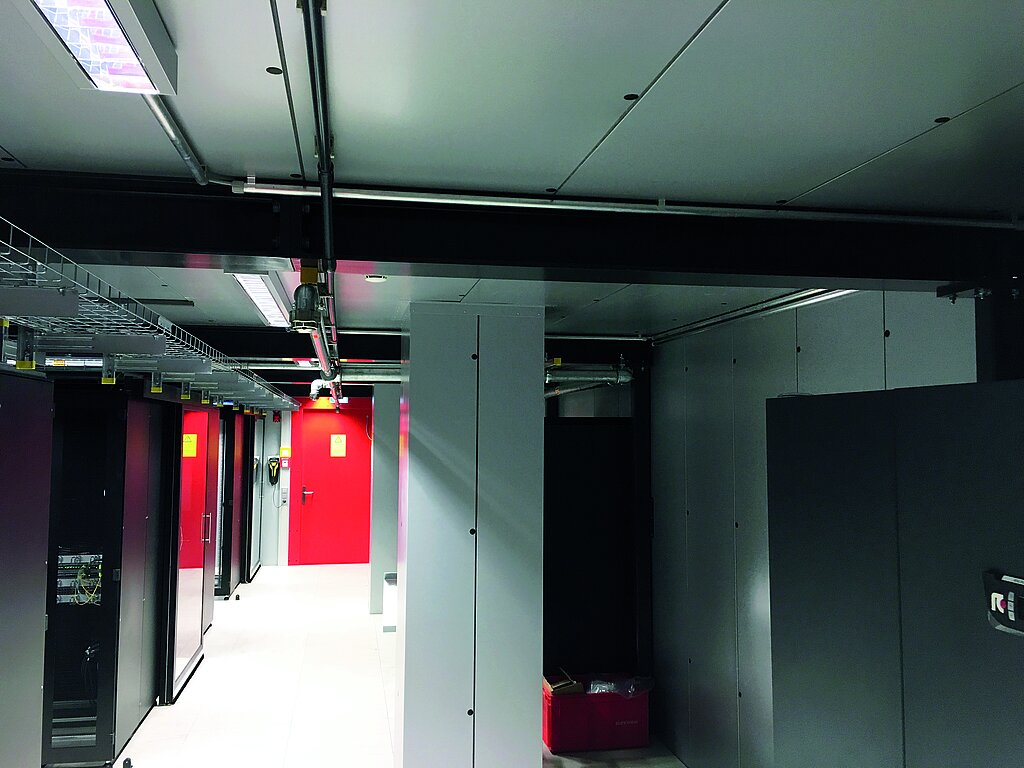 Basement room with black cabinets and in the background red door to the data center