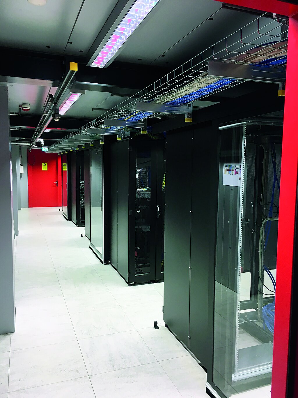 Cabinets on the right, in the background red door to the data center