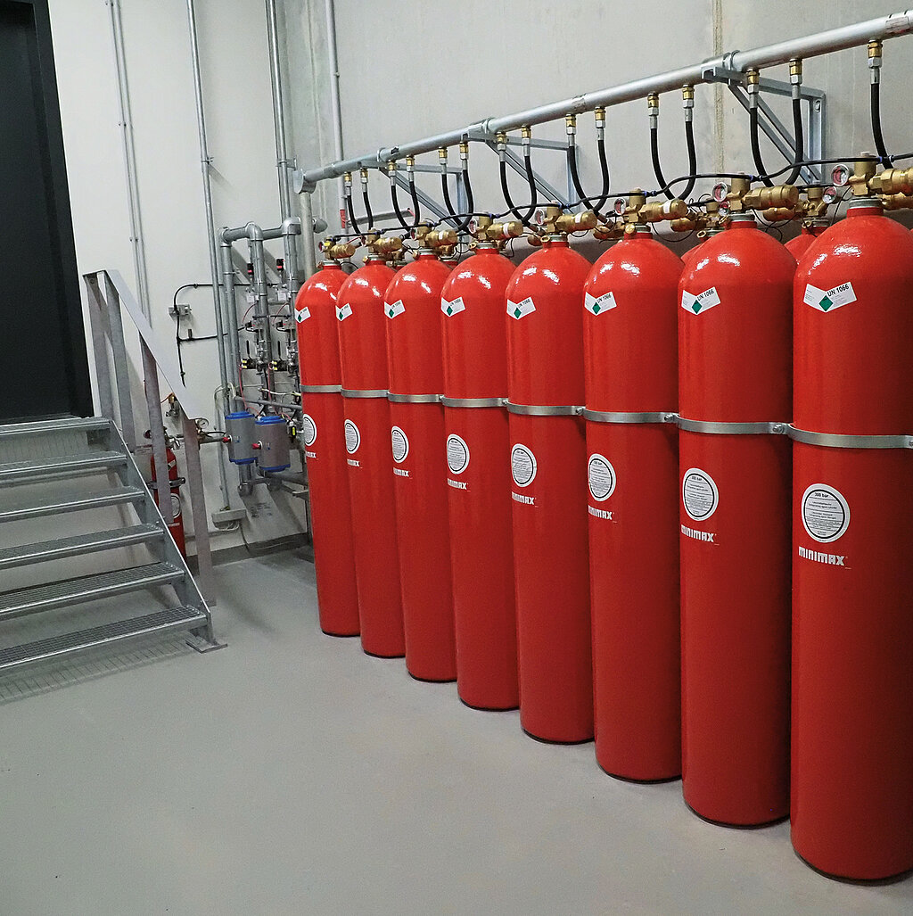 8 rote Feuerlöscher, links eine Treppe