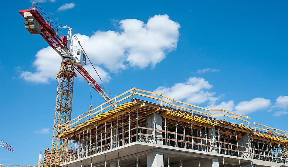 Baustelle mit Kran vor strahlend blauem Himmel