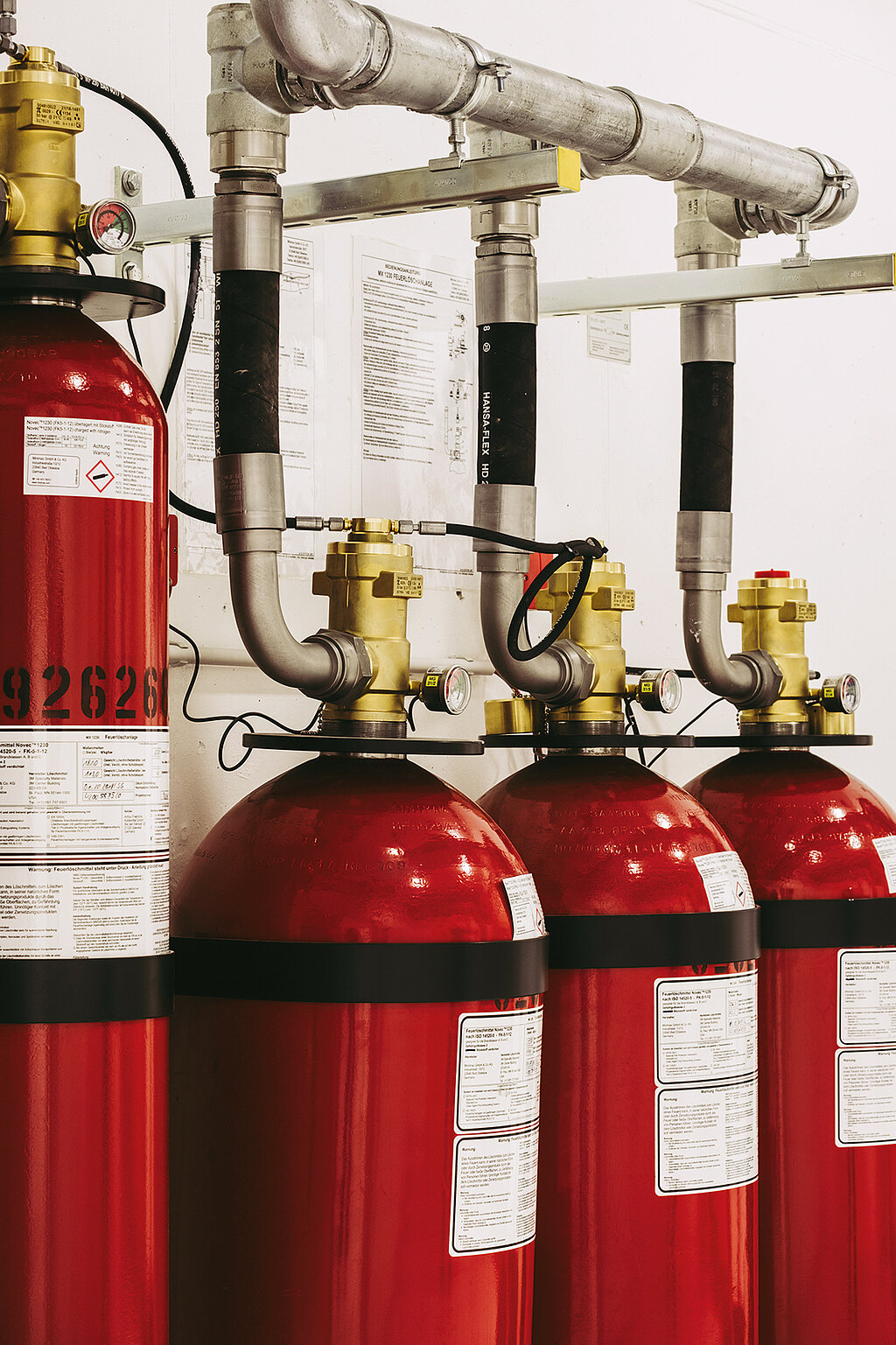 4 Feuerlöscher, an Rohren befestigt