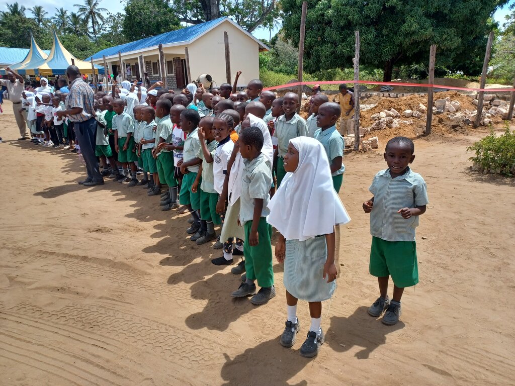 Schulkinder stehen in 3 Reihen, sie freuen sich.
