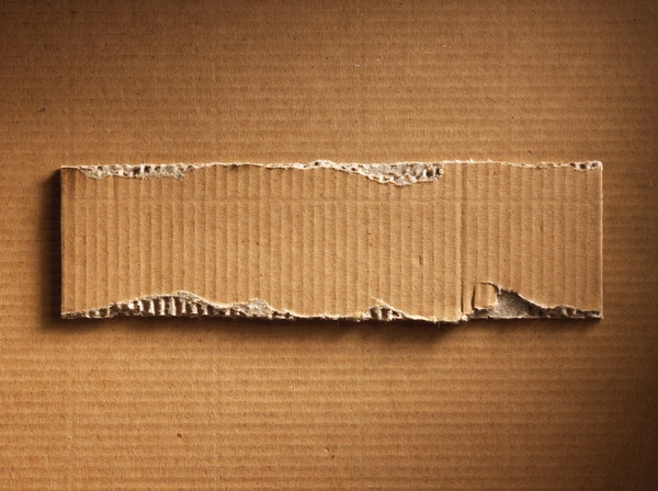 A piece of corrugated cardboard on beige background