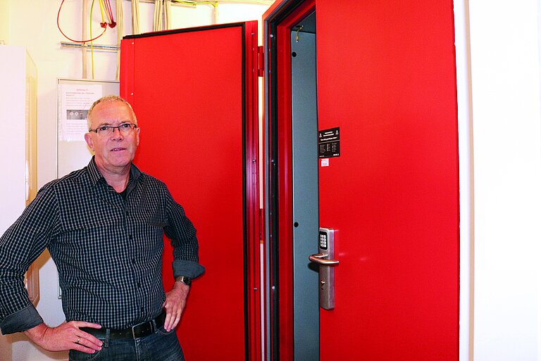 Man in front of an open DC IT safe in red