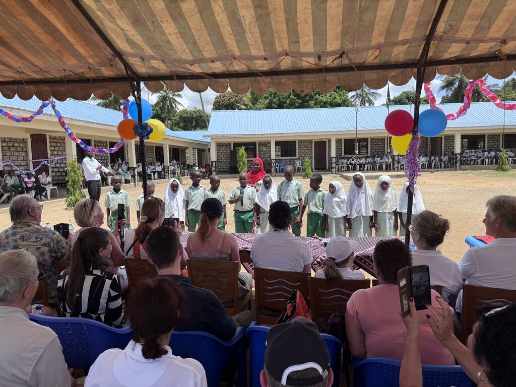 Schulkinder stehen in einer Reihe vor Publikum