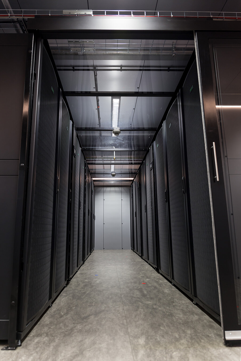 Zwei Reihen Server-Racks in den Cages im Datenraum des Rechenzentrums