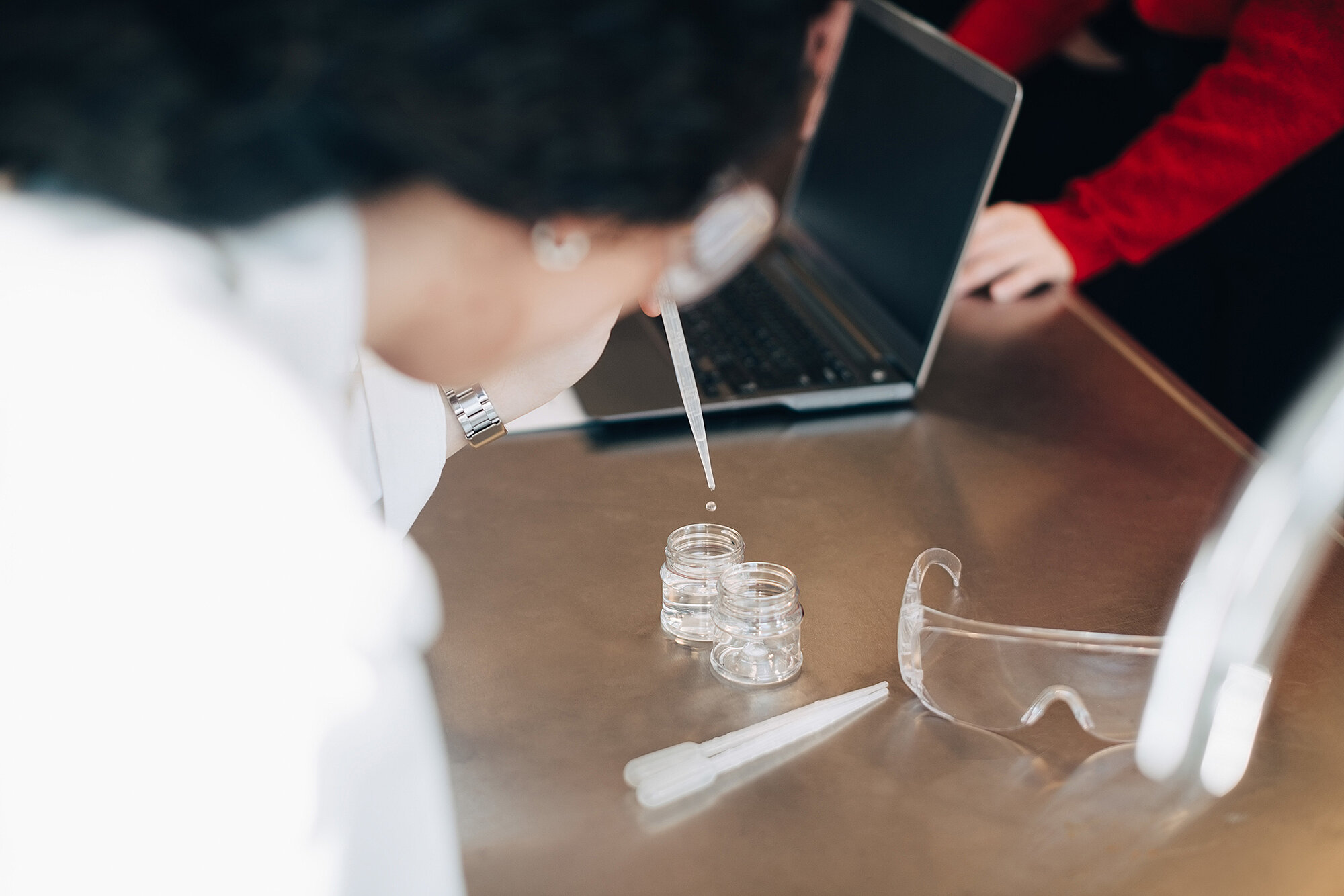 Chemists filling a test tube with a pipette