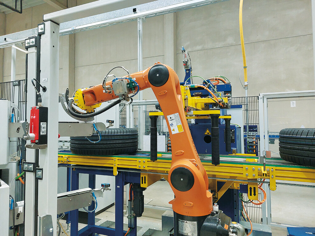 The digitized production line with orange gripper arm