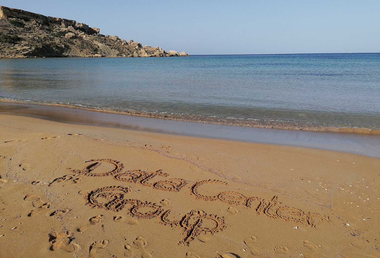 Sandy beach in Malta, where Data Center Group is written in the sand
