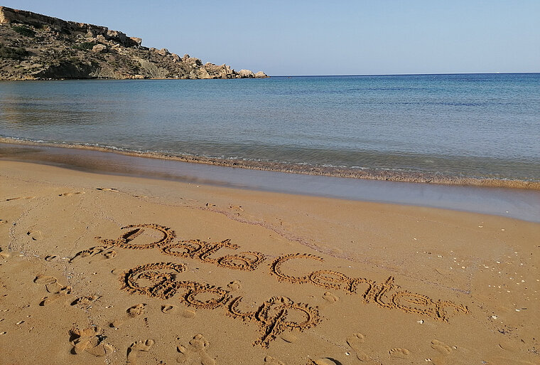 Sandstrand auf Malta, in dem Data Center Group im Sand geschrieben steht