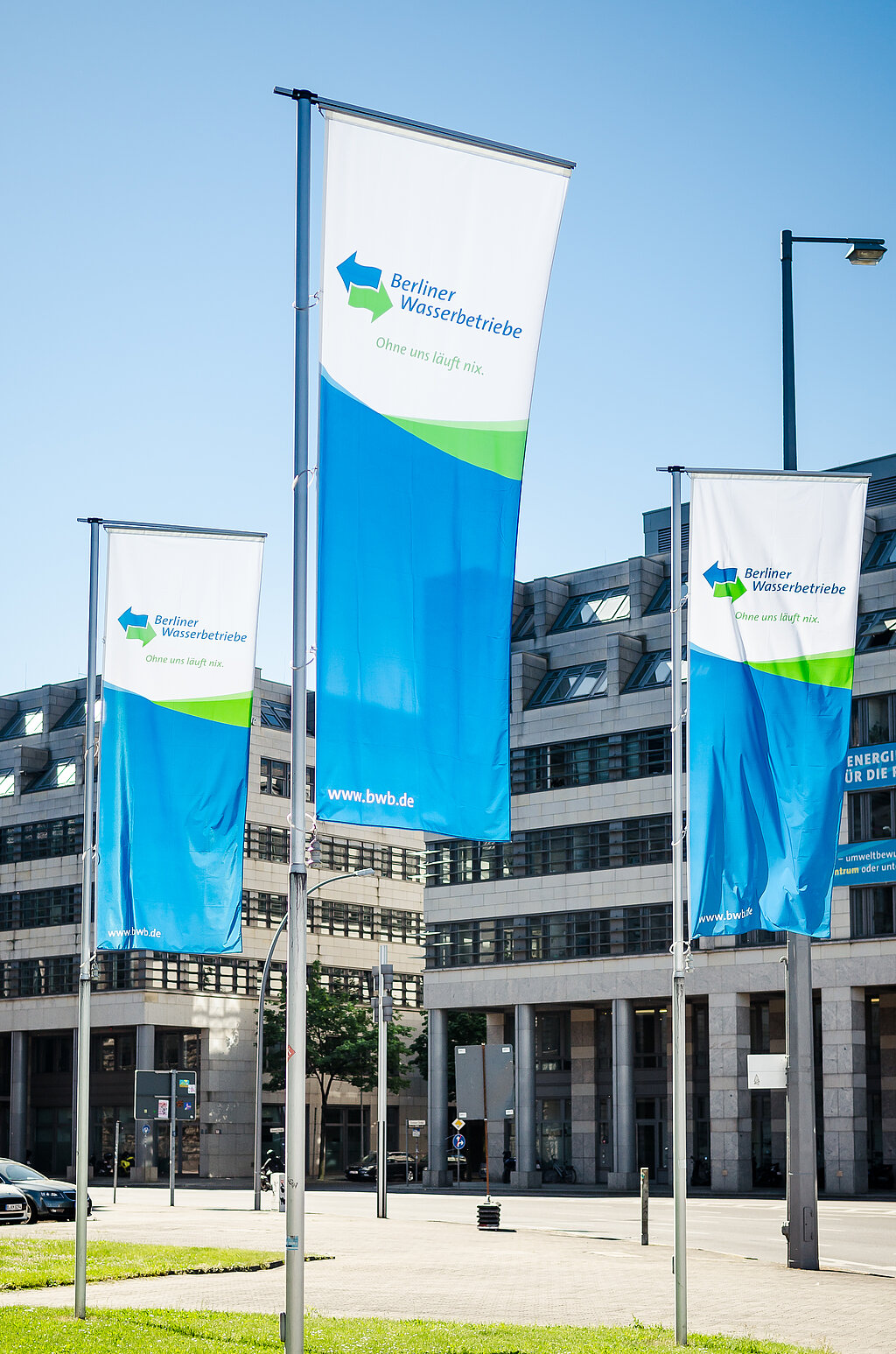 Gebäude Berliner Wasserbetriebe, davor 3 Fahnen der BWB