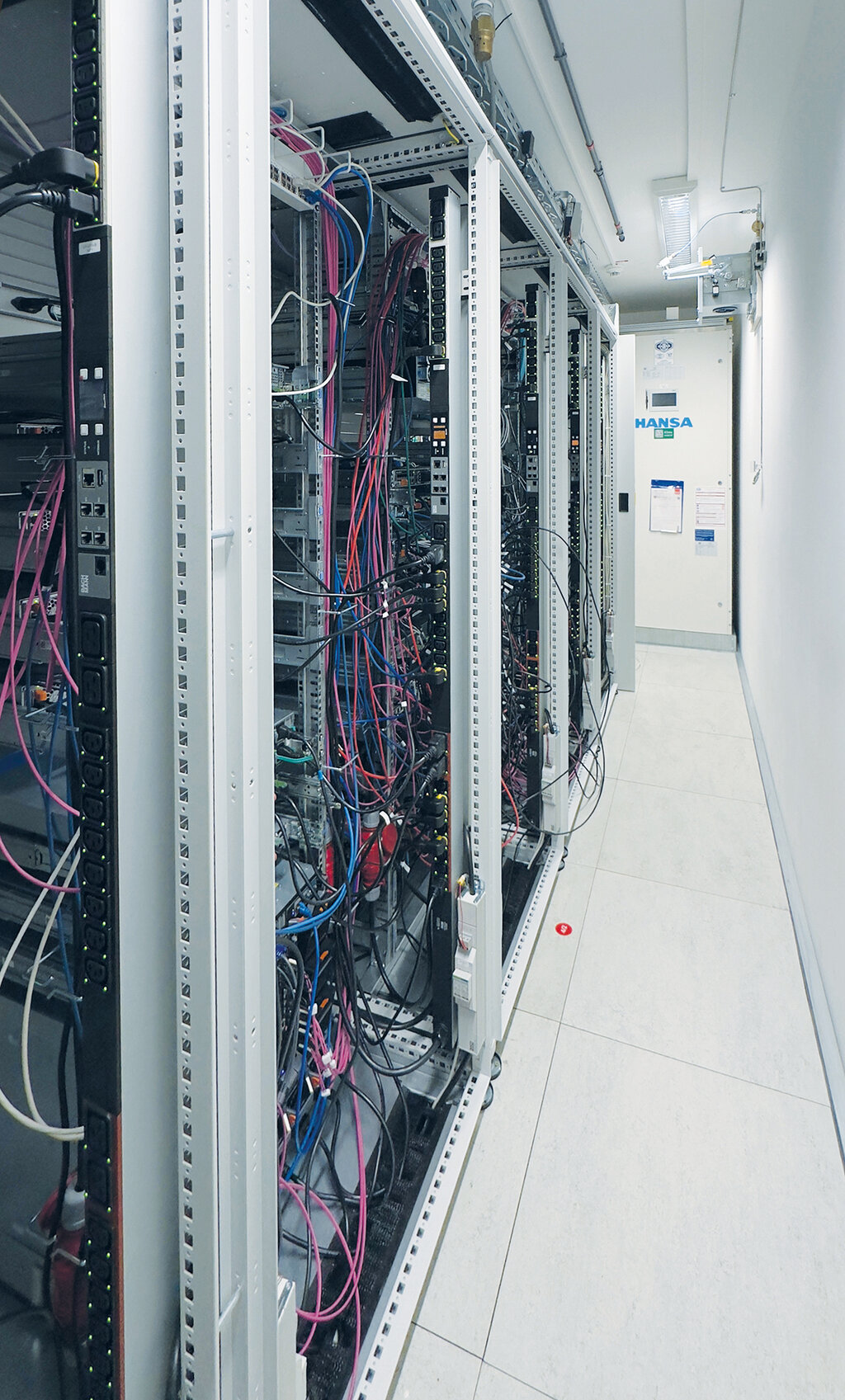 Rear view of the server racks with a view of the server room.