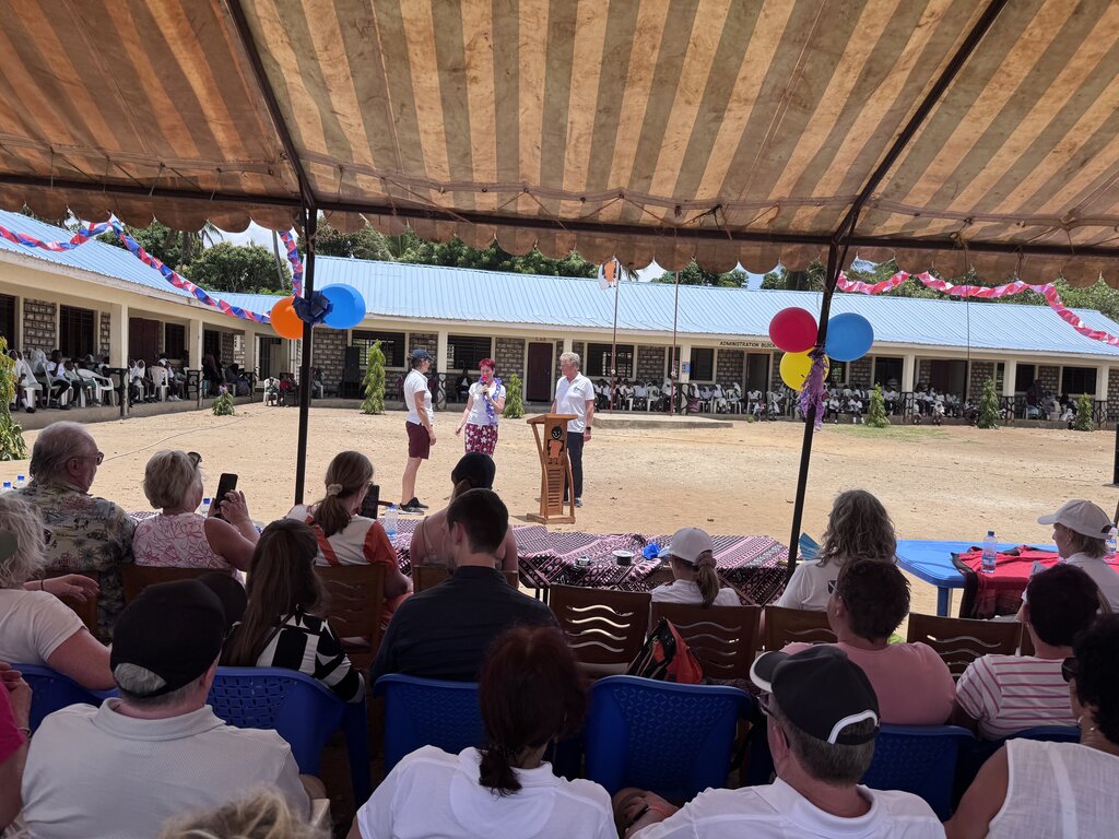 2 Frauen und 1 Mann halten eine Rede vor Publikum