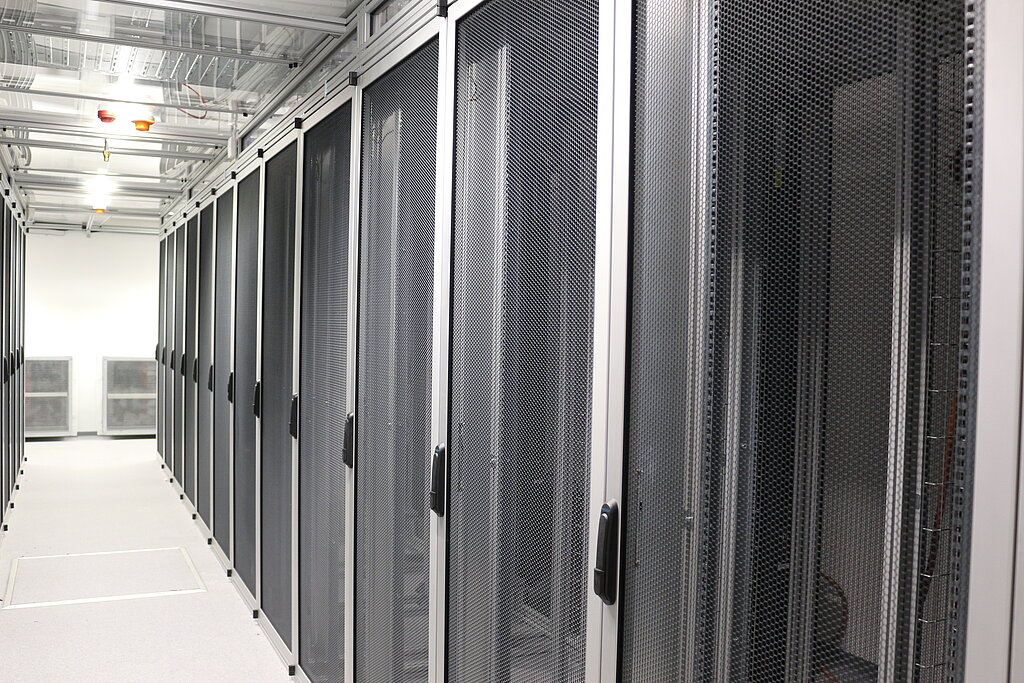 Server cabinets in black, on the left the server aisle, photographed obliquely