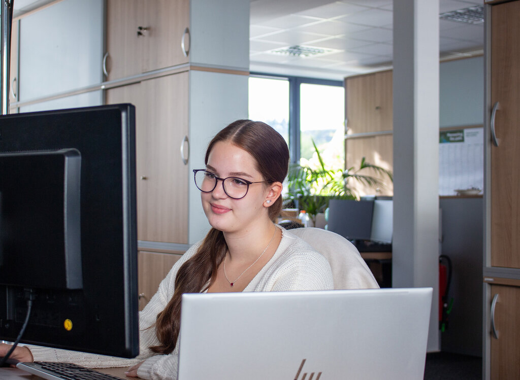 Nele am Schreibtisch sitzend und auf den Monitor blickend