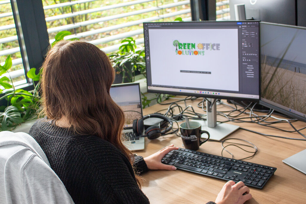 Caro blickt auf den Monitor, Rückansicht