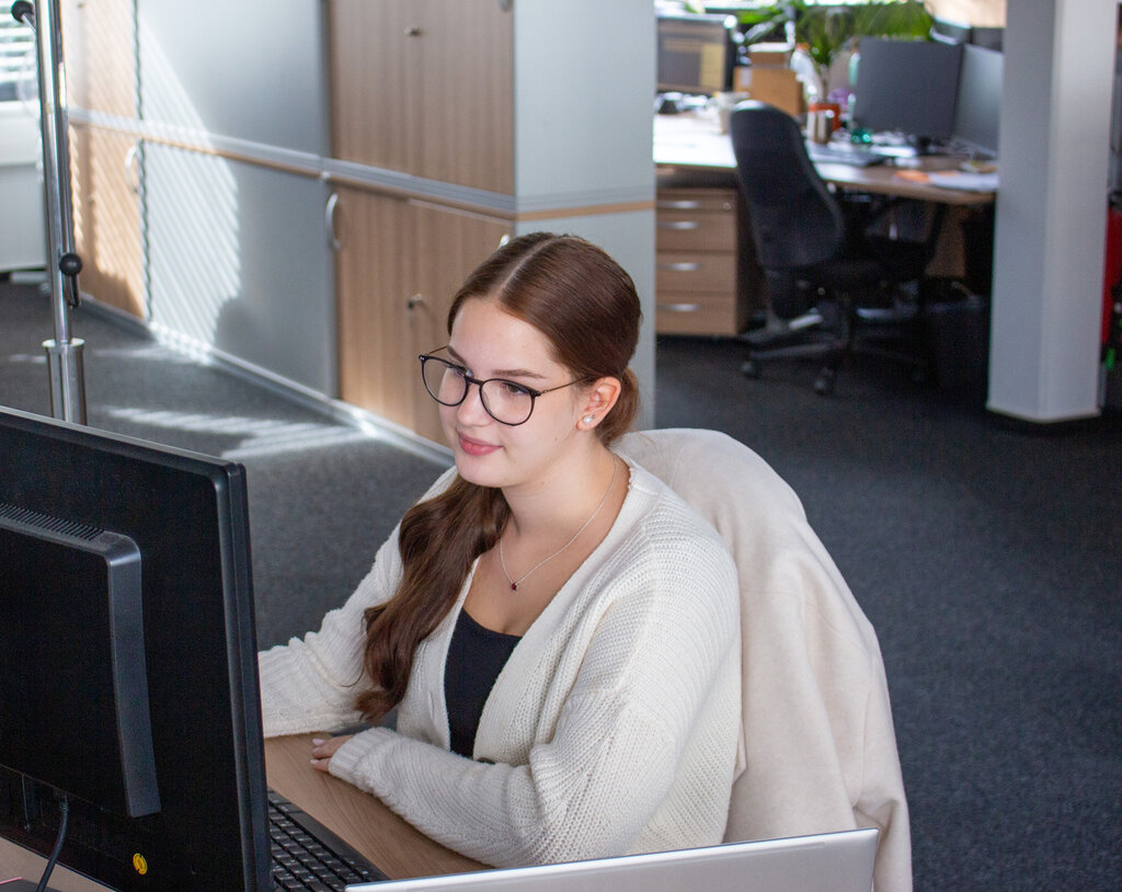 Nele am Schreibtisch sitzend und auf den Monitor blickend
