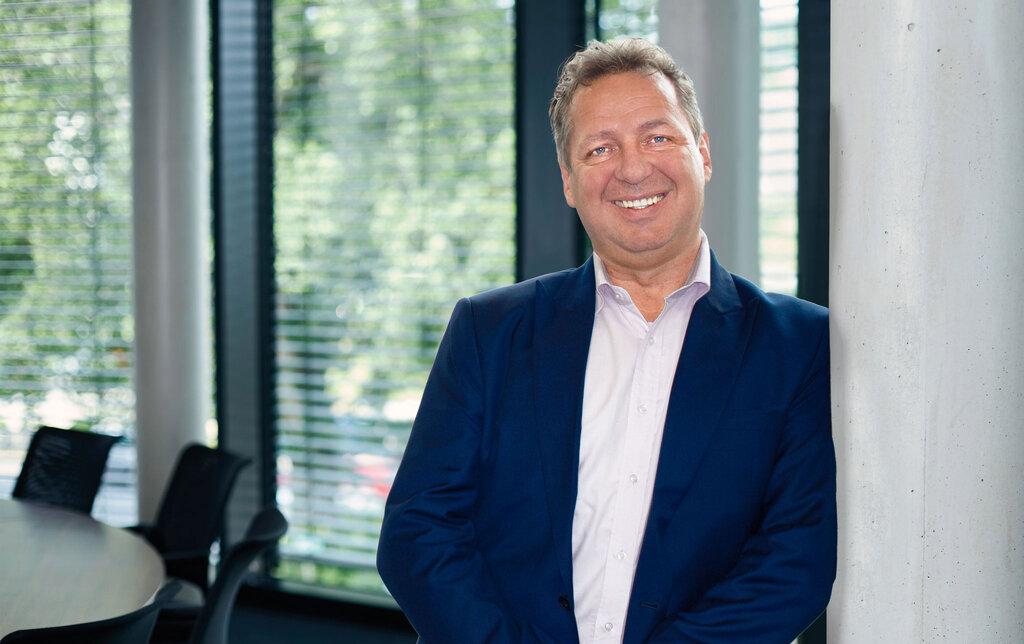 Portrait Dirk Doormann, Leiter strategischer Vertrieb und Business Development, lachend und stehend