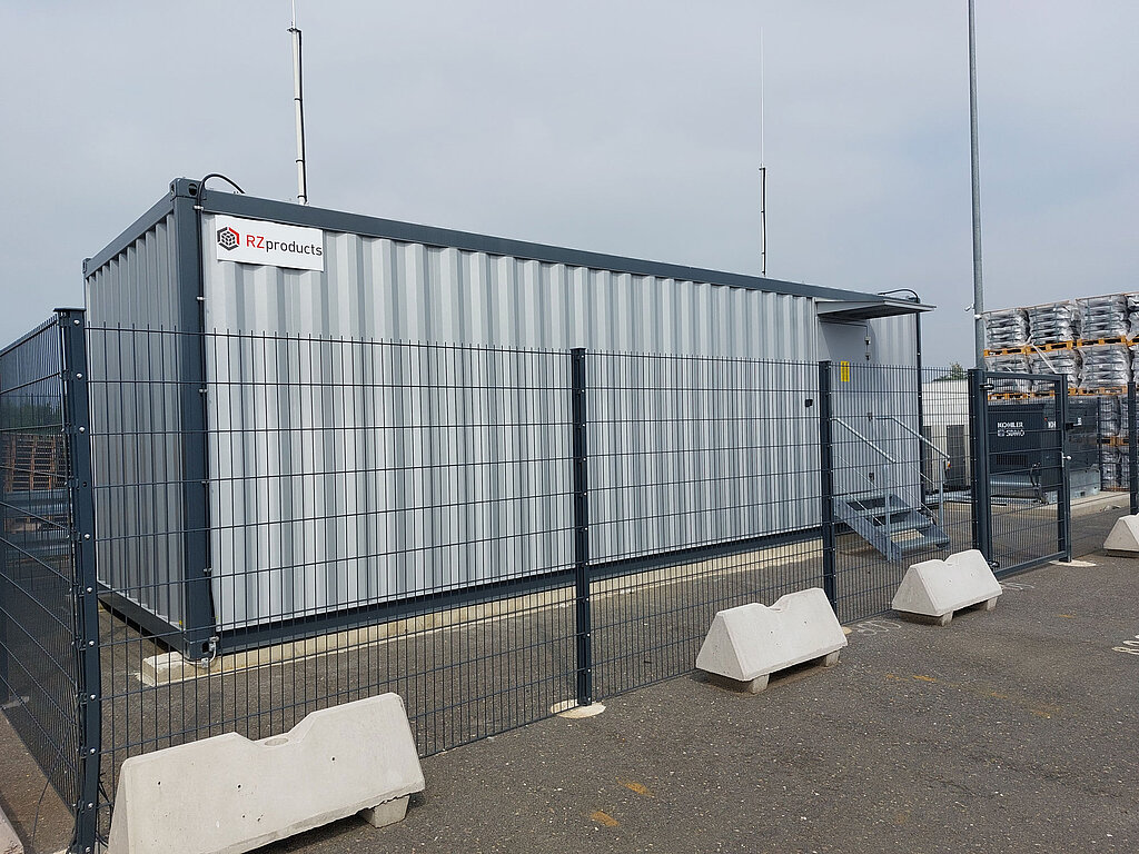 A data center container with a security fence in front of it