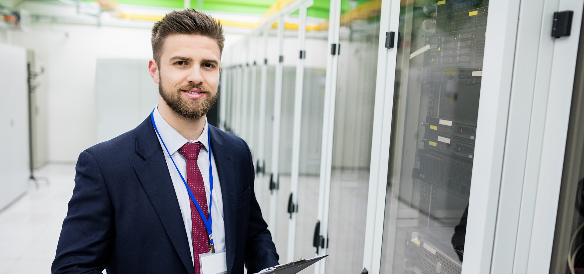 A man in a suit in front of IT safes.
