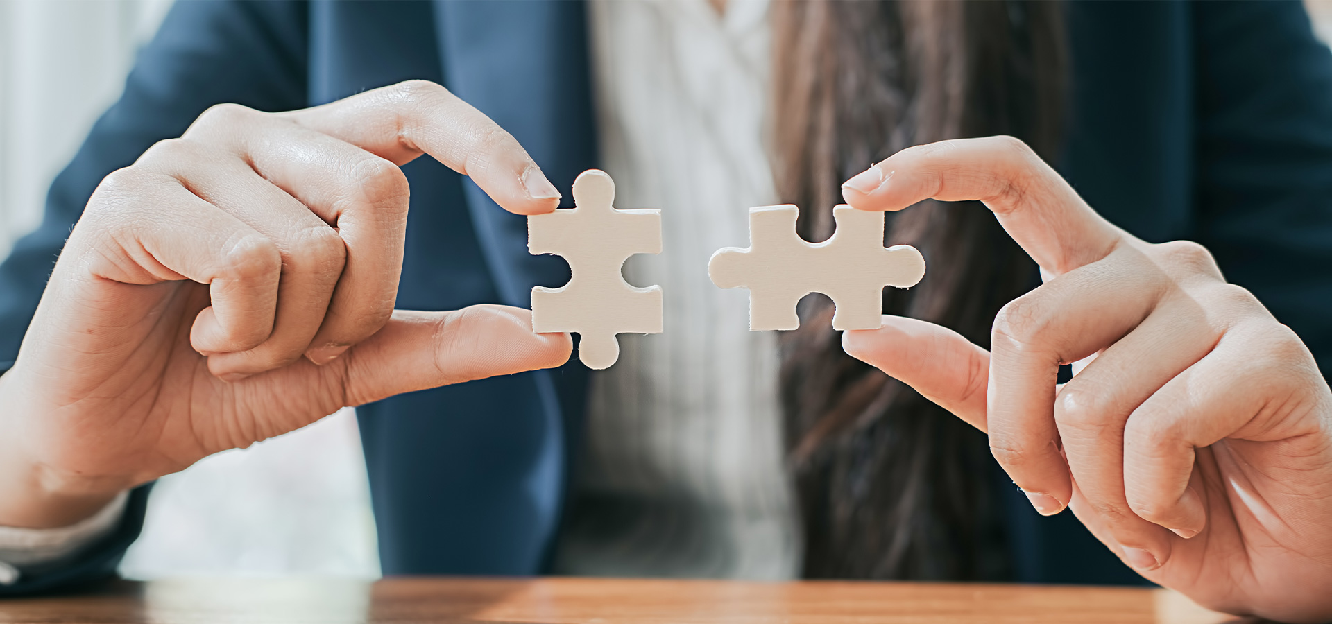 A woman is putting two puzzle pieces together.