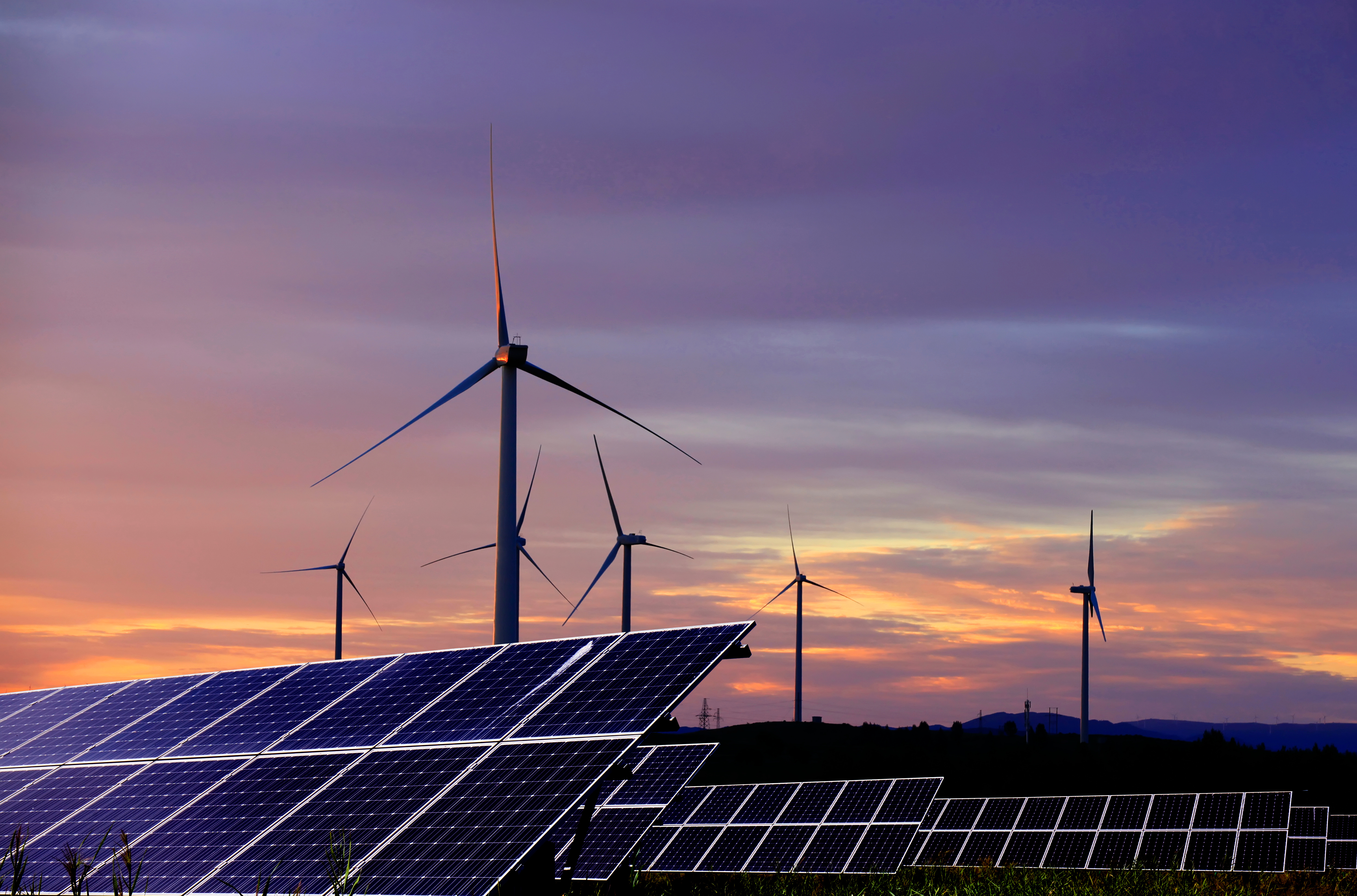 Solar-Photovoltaik-Module und Windturbinen im Hintergrund