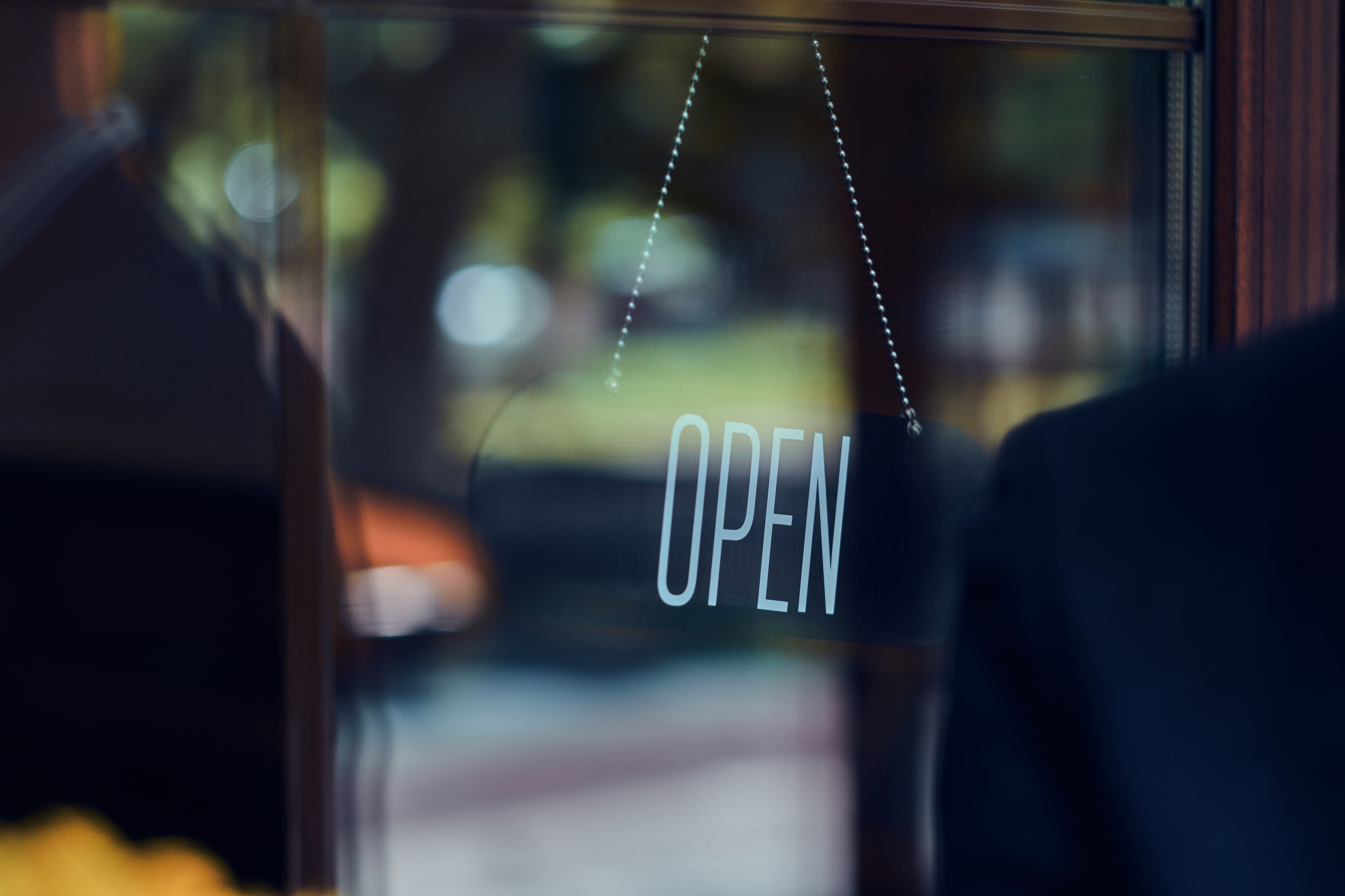 Fensterfront mit einem Schild, auf dem "open" steht